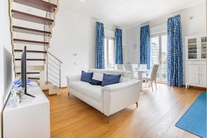 a living room with a white couch and blue curtains at Elena House Apartments in Viareggio