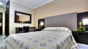una camera con letto, scrivania e specchio di Hotel Marbella a Città di Panama
