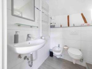 a white bathroom with a sink and a toilet at Eyes Ferienhaus im Nationalpark Eifel in Schleiden +37 photos