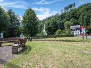 a park with a bench and a railroad crossing at Eyes Ferienhaus im Nationalpark Eifel in Schleiden