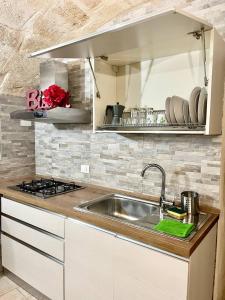 a kitchen with a sink and a stove at Perla Marina in Monopoli