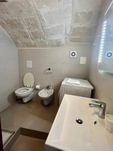 a white bathroom with a toilet and a sink at Perla Marina in Monopoli