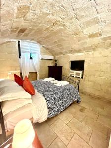 a bedroom with a bed in a stone wall at Perla Marina in Monopoli