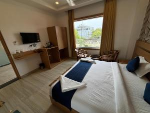 a hotel room with a large bed and a window at Hotel Royal Casa in Lucknow