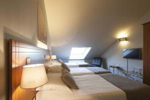 a hotel room with a large bed and a tv at Theater Hotel Leuven Centrum in Leuven