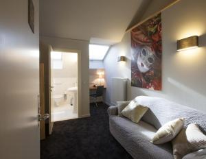 a bedroom with a bed and a bathroom with a sink at Theater Hotel Leuven Centrum in Leuven