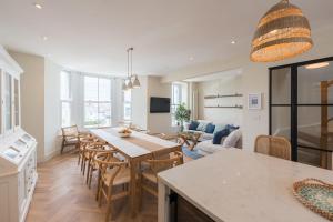 a kitchen and living room with a table and chairs at Wylfa The Upper House & The Hide by Birch Stay in Rhosneigr