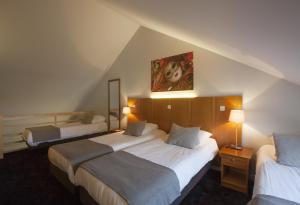 a hotel room with two beds and a painting on the wall at Theater Hotel Leuven Centrum in Leuven