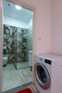 a washing machine in a bathroom with a shower at Vila Mario in Ksamil +93 photos