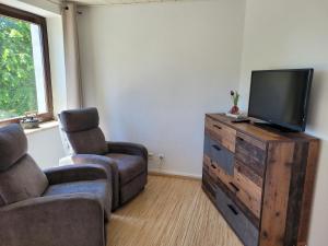 a living room with a tv and two chairs at Marktstube in Marsberg