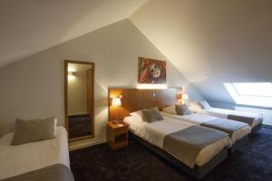 a hotel room with two beds and a mirror at Theater Hotel Leuven Centrum in Leuven