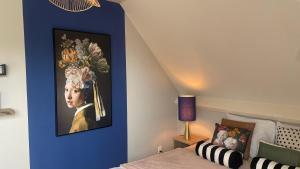 a bedroom with a painting of a child on a blue wall at Bungalowpark Mooyeveld in Egmond-Binnen