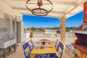 een patio met een tafel en stoelen en een wastafel bij Tenuta La Cornola by BarbarHouse in Taurisano