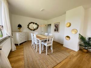 a dining room with a table and white chairs at Ferienwohnung Straußenblick Erdgeschoss - keine Monteure in Bad Fallingbostel