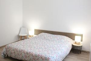 a bedroom with a bed and two lamps on tables at Maison 4 chambres 90 m in Aulnoye-Aymeries
