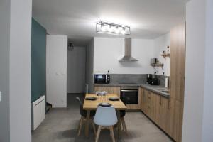 a kitchen with a table and chairs in a room at Maison 4 chambres 90 m in Aulnoye-Aymeries