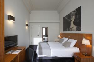a hotel room with a bed and a television at Theater Hotel Leuven Centrum in Leuven