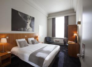 a hotel room with a large bed and a window at Theater Hotel Leuven Centrum in Leuven