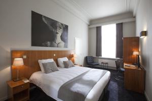 a hotel room with a bed and a large window at Theater Hotel Leuven Centrum in Leuven