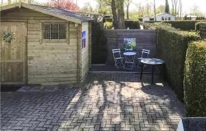 Eine Terrasse mit Tisch und Stühlen neben einem Schuppen in der Unterkunft 2 Bedroom Amazing Home In Tzummarum in Tzummarum