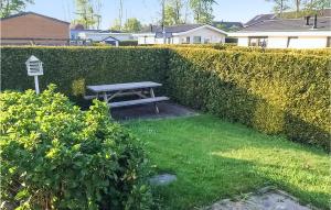 eine Picknickbank im Gras bei einer Hecke in der Unterkunft 2 Bedroom Amazing Home In Tzummarum in Tzummarum