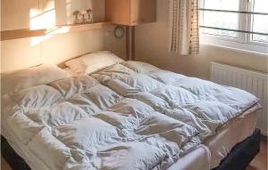 ein ungemachtes Bett in einem Zimmer mit Fenster in der Unterkunft 2 Bedroom Amazing Home In Tzummarum in Tzummarum