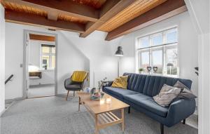 阿灵厄Lovely Apartment In Allinge With Wifi的客厅里有一张蓝色的沙发和一张桌子