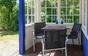 eine Veranda mit Tisch und Stühlen und Fenstern in der Unterkunft Beautiful Home In Nexø With Sauna in Neksø + 27 Fotos