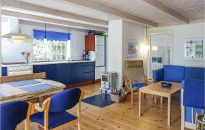 eine Küche und ein Esszimmer mit blauen Stühlen und einem Tisch in der Unterkunft Beautiful Home In Nexø With Sauna in Neksø