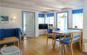ein Esszimmer mit einem Tisch und blauen Stühlen in der Unterkunft Beautiful Home In Nexø With Sauna in Neksø