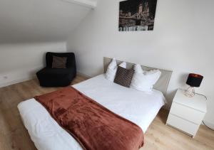 sypialnia z białym łóżkiem i czarnym krzesłem w obiekcie "Colbert Triplex" 3 chambres - Balcon - Patio - Cathédrale w Tours