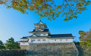 富山ホテルウォーターゲート富山 レジャーホテル 大人用ホテル的一座大建筑,墙上有塔