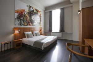 a bedroom with a bed and a painting on the wall at Theater Hotel Leuven Centrum in Leuven