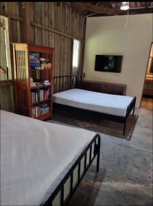 a bedroom with two beds and a tv in it at Vila Dravida Petar in Iporanga