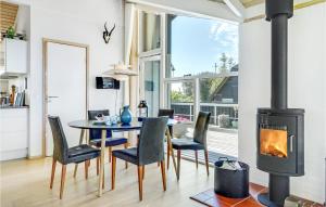 a living room with a fireplace and a table and chairs at Lovely Home In Vordingborg With Wifi in Vordingborg