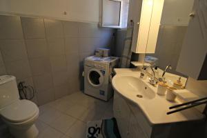 een badkamer met een wasmachine en een wasmachine en droger bij Joanna's House in Skala Kallirakhis