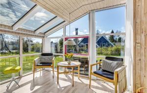 a conservatory with windows and a table and chairs at Holiday Home Gøgeurtvej Væggerløse X in Marielyst