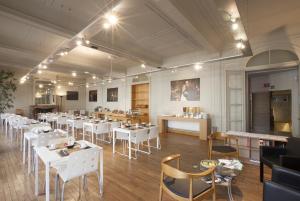 a restaurant with white tables and chairs in a room at Theater Hotel Leuven Centrum in Leuven +16 photos