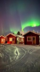 a house with the aurora in the sky at Lapland Arctic Cabins in Kemijärvi