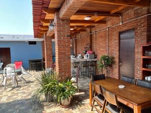 a patio with a brick wall and a table and chairs at Casa Belisario - Pet Friendly in Mazatlán