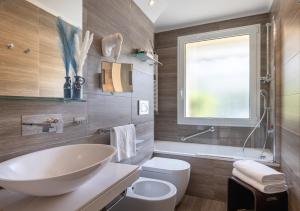 a bathroom with a sink and a toilet and a window at Hotel Metropole in Santa Margherita Ligure