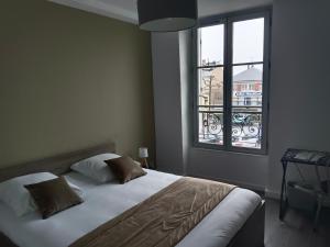 a bedroom with a bed and a large window at hotel de france in Vatan