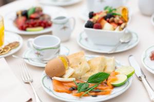 a table with plates of food and a bowl of fruit at Hotel Metropole in Santa Margherita Ligure