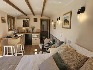 a living room with a couch and a kitchen at Stoodley View Shepherd Huts in Todmorden