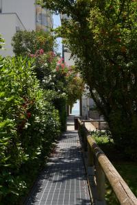 a walkway with bushes and flowers on a building at APPARTAMENTO MARCONI B2 in Lido di Jesolo