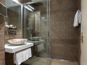 a bathroom with a glass shower and a sink at Hotel Metropole in Santa Margherita Ligure