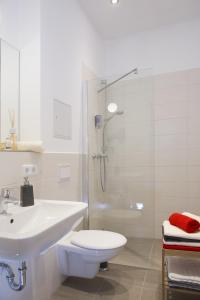 a bathroom with a toilet and a sink and a shower at Leon Suite Apartments in Leipzig +23 photos