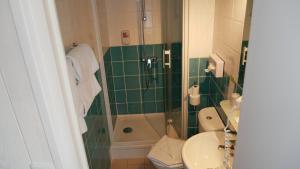 a bathroom with a shower and a toilet and a sink at Brit Hotel des Halles in Concarneau