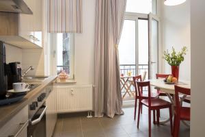 uma cozinha e sala de jantar com uma mesa e uma janela em Leon Suite Apartments em Leipzig