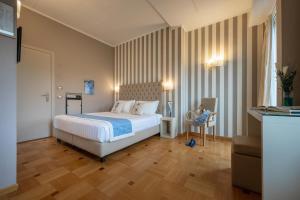 a bedroom with a bed and a chair in a room at Hotel Metropole in Santa Margherita Ligure